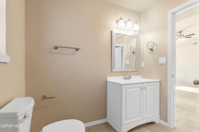 bathroom with toilet, baseboards, ceiling fan, and vanity