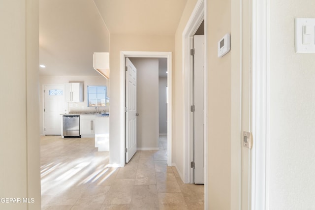 corridor with a sink and light tile patterned flooring