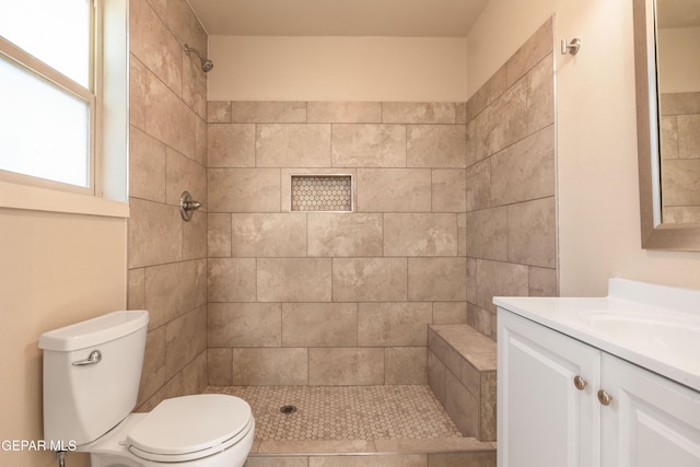 full bathroom featuring vanity, toilet, and a tile shower