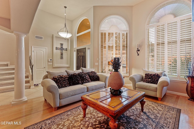 6225 Via Serena Dr, El Paso, TX 79912 - living room featuring ornate columns, stairs, light wood-type flooring, and baseboards