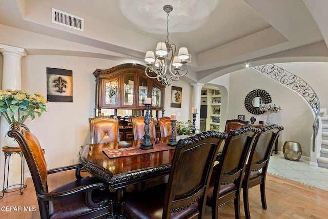 6225 Via Serena Dr, El Paso, TX 79912 - dining area with ornate columns, arched walkways, a chandelier, and a raised ceiling