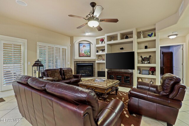6225 Via Serena Dr, El Paso, TX 79912 - living room with light tile patterned floors, built in features, a ceiling fan, and a tiled fireplace