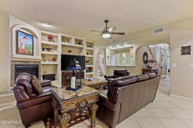 6225 Via Serena Dr, El Paso, TX 79912 - living room with arched walkways, light tile patterned floors, a ceiling fan, and a glass covered fireplace