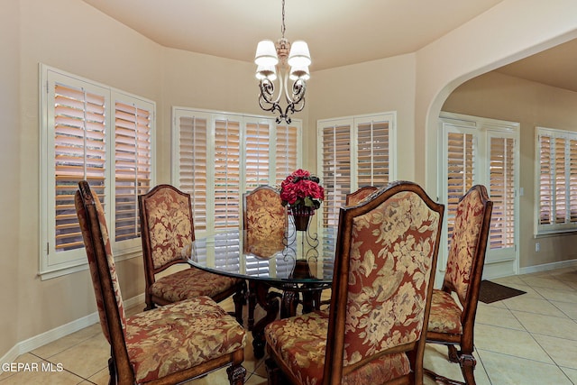 6225 Via Serena Dr, El Paso, TX 79912 - tiled dining area featuring a chandelier, arched walkways, and baseboards