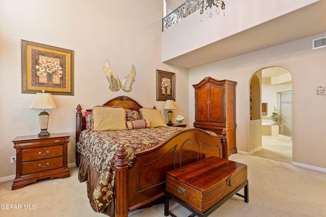 6225 Via Serena Dr, El Paso, TX 79912 - bedroom with light carpet, baseboards, arched walkways, ensuite bath, and a high ceiling