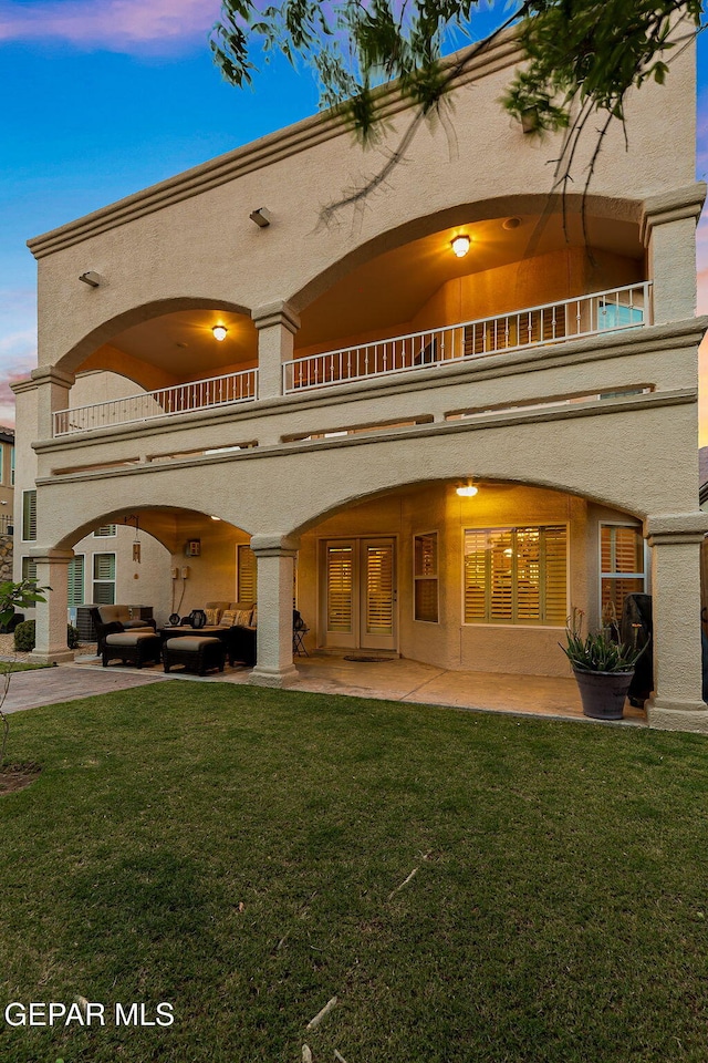 6225 Via Serena Dr, El Paso, TX 79912 - back of house at dusk featuring a balcony, an outdoor living space, french doors, and a patio area