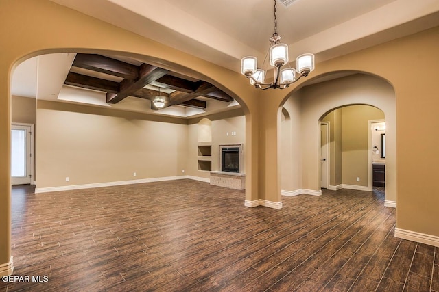 unfurnished living room with coffered ceiling, dark wood-type flooring, baseboards, beamed ceiling, and a glass covered fireplace