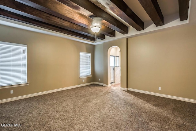 carpeted spare room featuring arched walkways, beamed ceiling, baseboards, and a ceiling fan