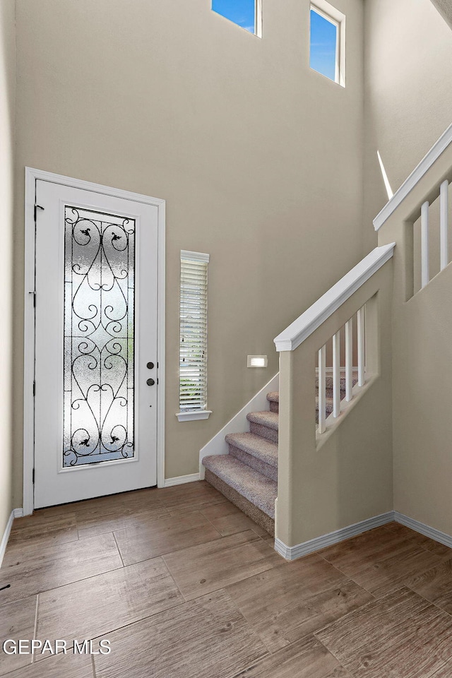 7541 Wolf Creek Dr, El Paso, TX 79911 - entrance foyer with stairs, a high ceiling, wood finished floors, and baseboards