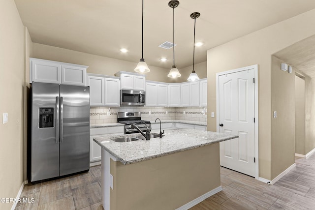 7541 Wolf Creek Dr, El Paso, TX 79911 - kitchen with appliances with stainless steel finishes, backsplash, white cabinetry, baseboards, and a kitchen island with sink