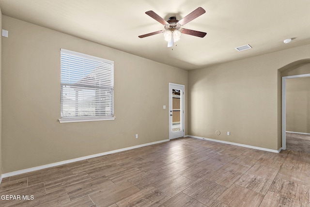 7541 Wolf Creek Dr, El Paso, TX 79911 - empty room with ceiling fan, light wood-style floors, arched walkways, and baseboards