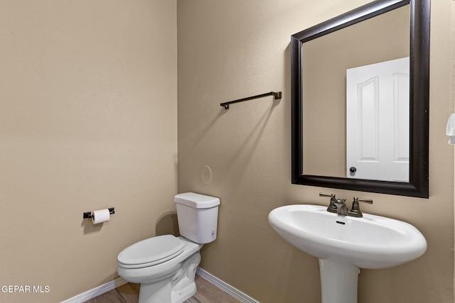 7541 Wolf Creek Dr, El Paso, TX 79911 - half bathroom featuring toilet, baseboards, wood finished floors, and a sink