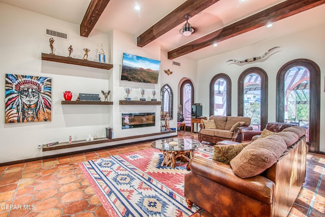 tiled living area with a glass covered fireplace, beamed ceiling, recessed lighting, and baseboards