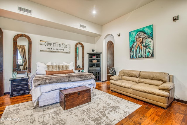 bedroom with arched walkways, hardwood / wood-style flooring, and recessed lighting