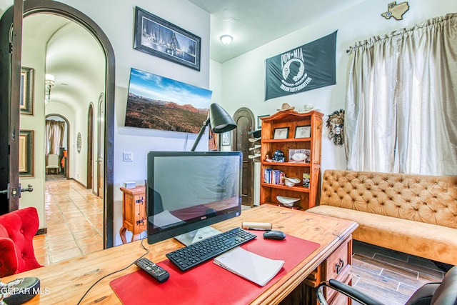 tiled home office featuring arched walkways