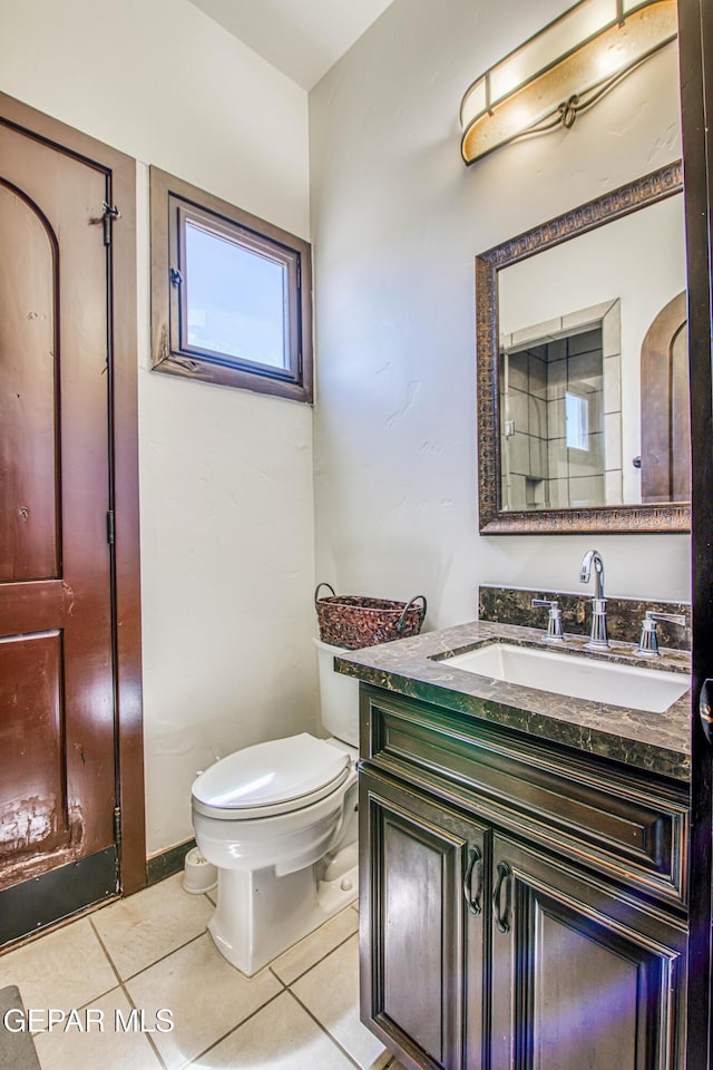 bathroom with tile patterned flooring, toilet, and vanity