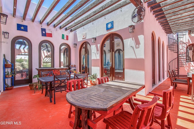 view of patio with outdoor dining area and stairs