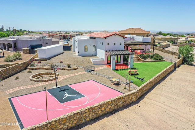 view of basketball court featuring community basketball court, a residential view, and fence