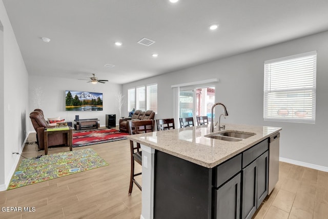 13868 Sky Ranger Ave, El Paso, TX 79928 - kitchen with a sink, stainless steel dishwasher, an island with sink, a ceiling fan, and light wood-style flooring