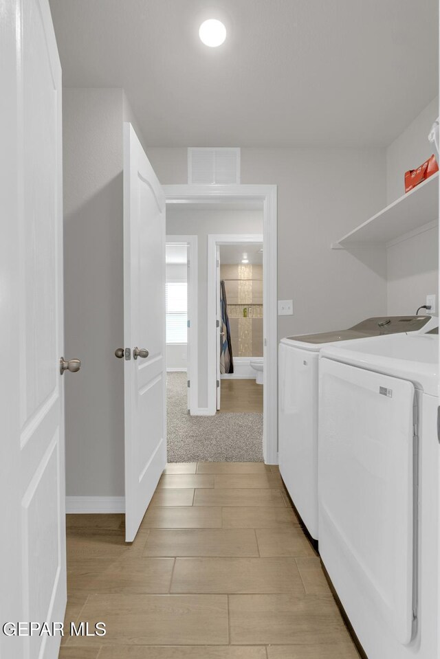 13868 Sky Ranger Ave, El Paso, TX 79928 - laundry room featuring washing machine and dryer, light wood-style flooring, and baseboards