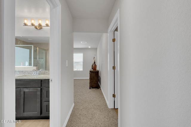 13868 Sky Ranger Ave, El Paso, TX 79928 - hall featuring baseboards, a sink, and light colored carpet
