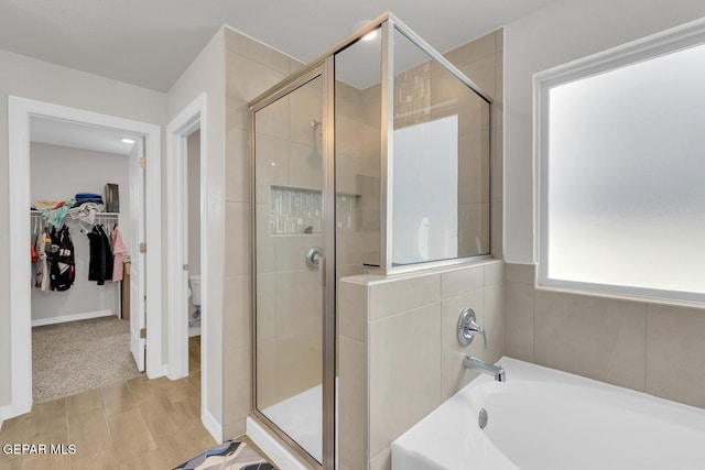 13868 Sky Ranger Ave, El Paso, TX 79928 - full bath with a shower stall, a bath, a walk in closet, and wood finished floors