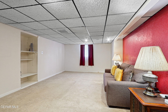 carpeted living room with baseboards and a paneled ceiling