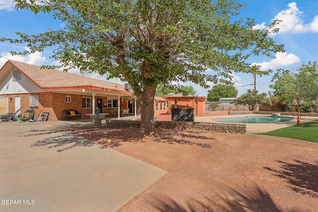 back of house featuring a gazebo, a patio, an outdoor pool, and brick siding