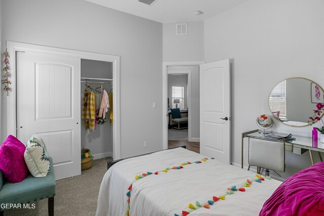 bedroom with a closet, visible vents, baseboards, and carpet