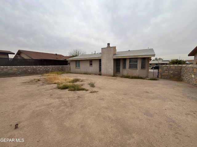 8434 Villanova Dr, El Paso, TX 79907 - rear view of property with fence, a gate, and a chimney