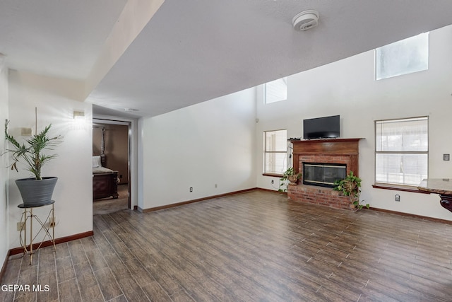 1759 Green Gate Way, El Paso, TX 79936 - living room featuring wood finished floors, baseboards, a brick fireplace, and a towering ceiling