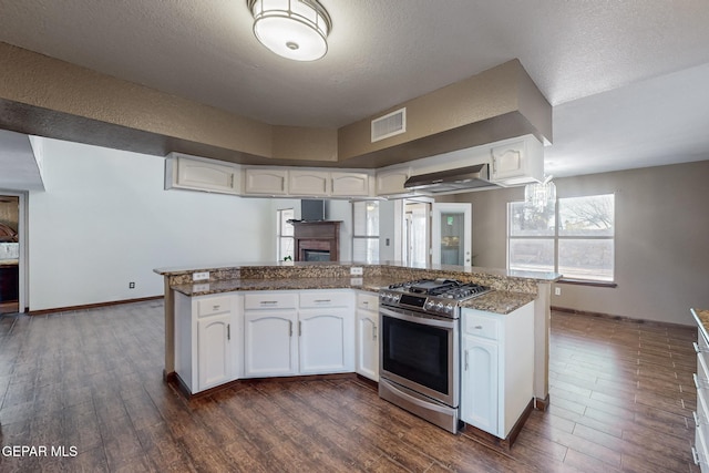 1759 Green Gate Way, El Paso, TX 79936 - kitchen with stainless steel range with gas cooktop, dark wood finished floors, white cabinets, a textured ceiling, and a fireplace