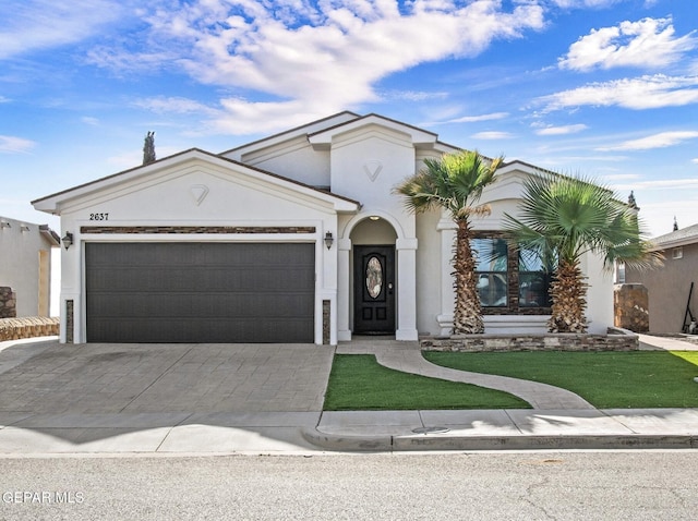 view of front of property with stucco siding, a garage, and decorative driveway