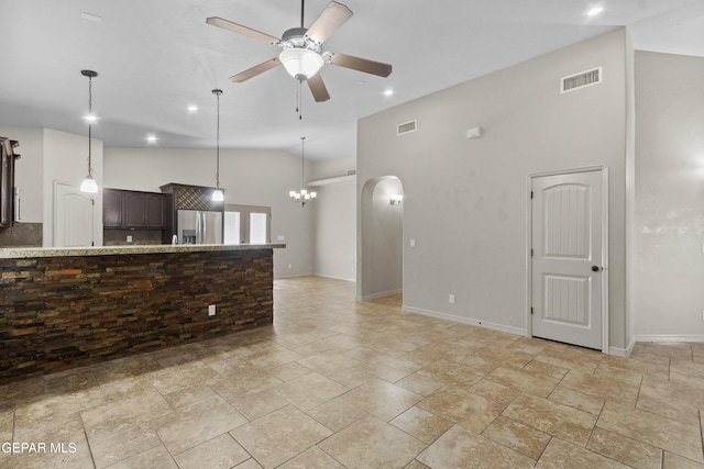 unfurnished living room featuring baseboards, visible vents, and ceiling fan with notable chandelier