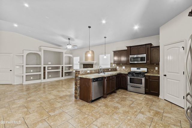 kitchen with a peninsula, a ceiling fan, a sink, stainless steel appliances, and dark brown cabinetry