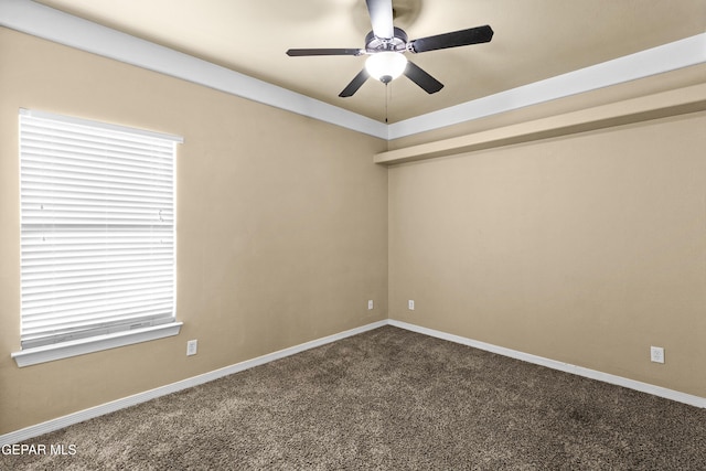 spare room featuring dark colored carpet, baseboards, and a ceiling fan