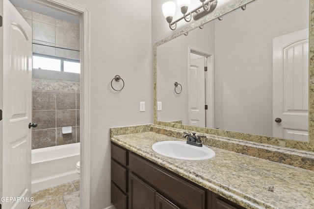 full bathroom featuring toilet, vanity, and stone finish flooring