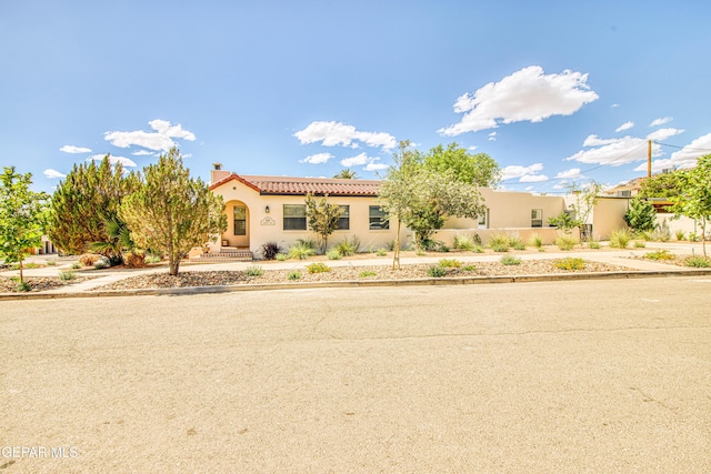 mediterranean / spanish home with stucco siding and a tiled roof