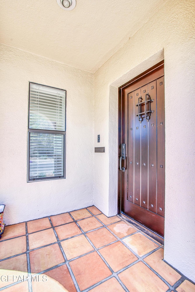 entrance to property featuring stucco siding