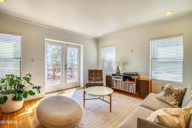 living area with crown molding, plenty of natural light, french doors, light wood-style floors, and baseboards