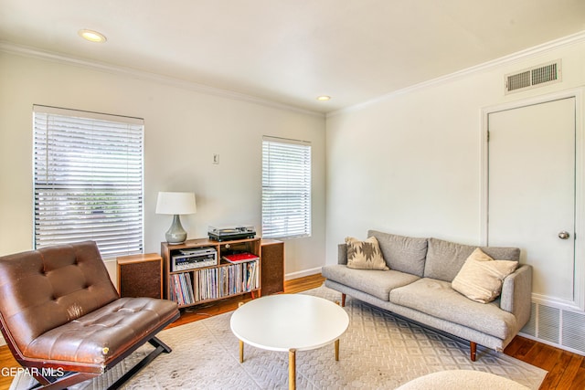living area featuring wood finished floors, ornamental molding, baseboards, and recessed lighting