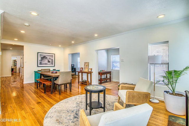 living area with ornamental molding, recessed lighting, light wood-style floors, and baseboards