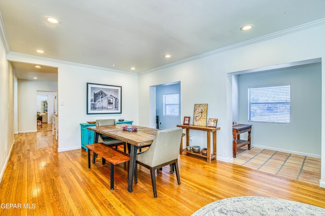 dining room featuring ornamental molding, healthy amount of natural light, light wood finished floors, recessed lighting, and baseboards