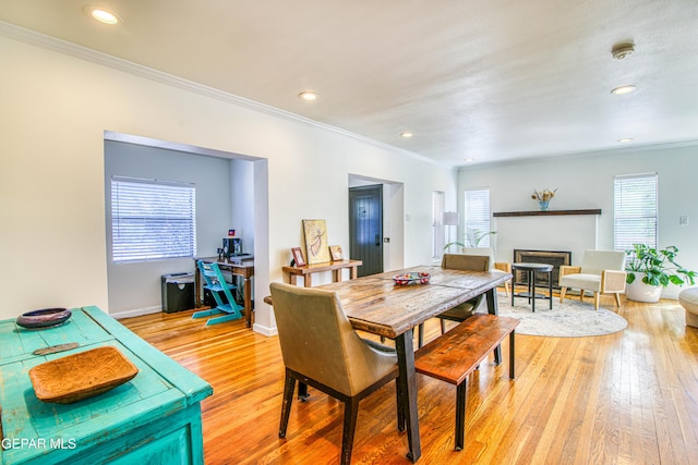 dining space with ornamental molding, a fireplace, light wood-style floors, recessed lighting, and baseboards