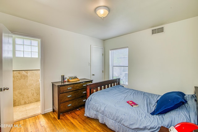 bedroom with multiple windows and hardwood / wood-style flooring