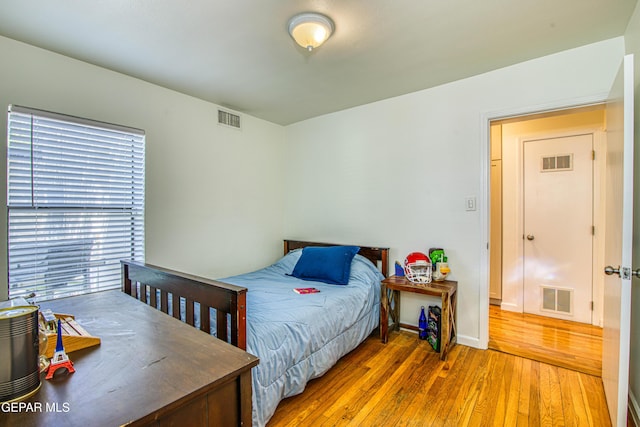 bedroom featuring wood-type flooring and baseboards