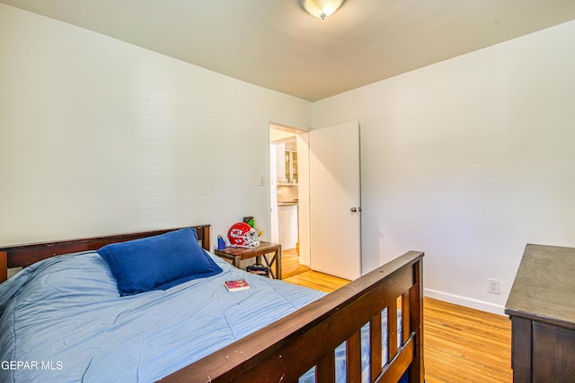 bedroom featuring light wood-style floors and baseboards
