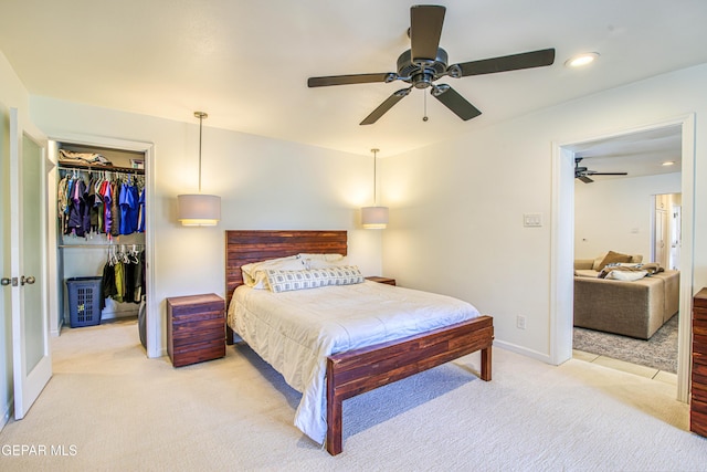 bedroom featuring light colored carpet, a spacious closet, a closet, baseboards, and recessed lighting