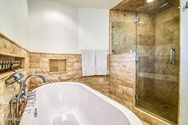 full bathroom with a bath and a stall shower