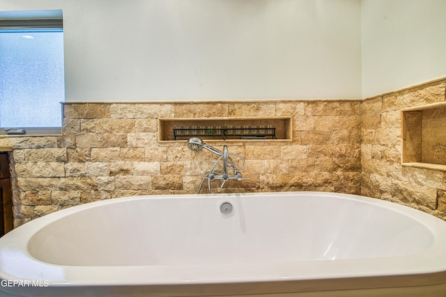 bathroom with a bath and plenty of natural light